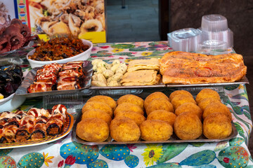 Delicious fresh cooked street food on daily food market in Palermo, Sicily, travel destination, food tourism Italy, variety of roasted, grilled fish, seafood, meat, vegetables served snacks, dish