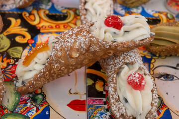 Homemade sweet pastry cannolo sfoglie filled with almond, pistachio, lemon, vanilla, chocolate cream on food market in Palermo, Sicily, Italy