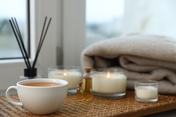Spa composition with burning candles and reed air freshener on windowsill, selective focus