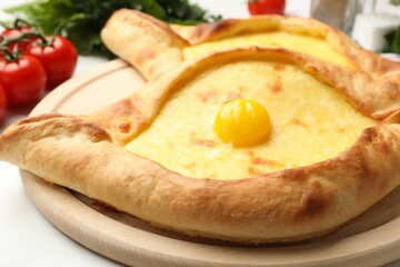 Tasty khachapuris with cheese and egg on white table, closeup