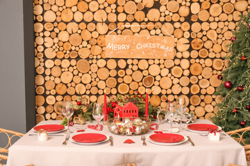 Table served for Christmas dinner near wooden wall