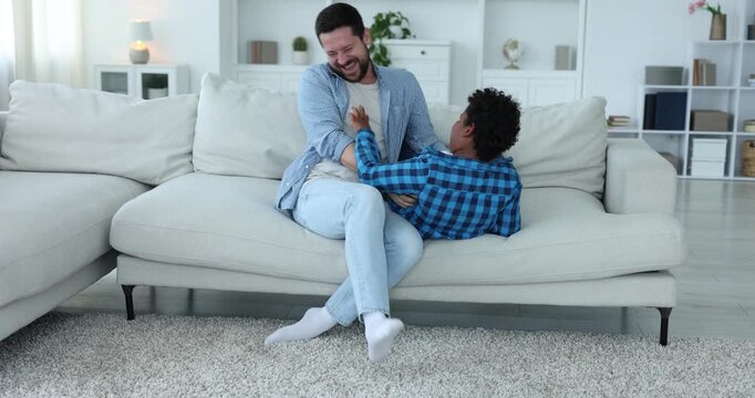 Adoption. Father and his son having fun together at home