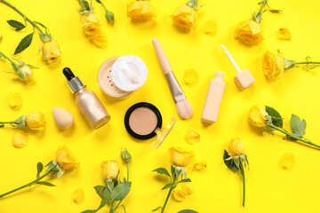 Beautiful composition with flowers and decorative cosmetics on yellow background