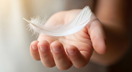 Delicate white feather rests gently on a person s open palm