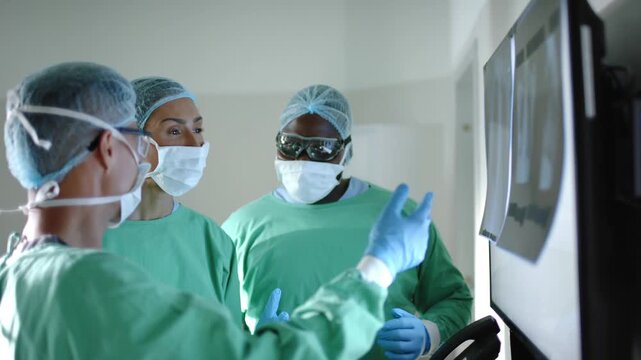 serious diverse surgeons with face masks inspecting xray in operating room in slow motion 4k video