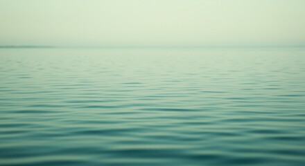 Fototapeta premium A serene and tranquil expanse of calm, rippled ocean water under a soft, hazy sky, evoking a sense of peaceful meditation and natural beauty in a timeless setting