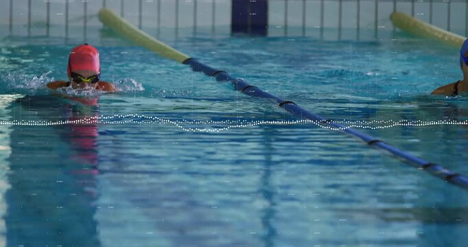 swimmer adjusting goggles and starting breaststroke in sports pool alongside teammate matching pace