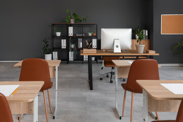 School desks with chairs in stylish classroom prepared for exam