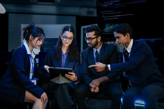 A diverse team of AI strategists in a project huddle, reviewing a neural network design on a tablet. A concept for agile development, collaborative problem-solving, and tech innovation.