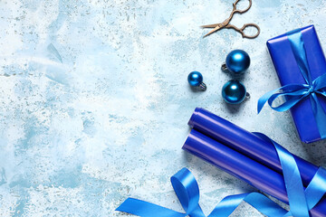 Christmas gift boxes with packing materials and decorations on grunge blue background