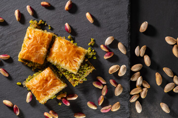 Traditional pistachio baklava on granite. Close-up of pistachio baklava on granite background. Turkish dessert baklava with pistachios. Pistachio baklava on stone surface.