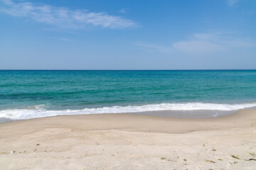 tranquil seascape with clouds in the sky and waves on the beach