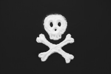 Human skull made of scattered sugar on black background