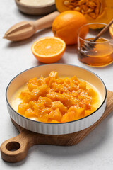 Healthy dessert with sliced pumpkin, honey and orange juice in a bowl. Healthy pumpkin dish.