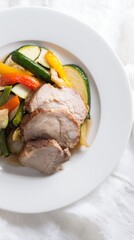 Juicy roasted pork with vegetables on a white plate, presented in a simple yet appetizing style.
