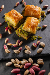 Traditional pistachio baklava on granite. Close-up of pistachio baklava on granite background. Turkish dessert baklava with pistachios. Pistachio baklava on stone surface.