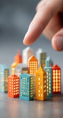 A finger points at a miniature city model