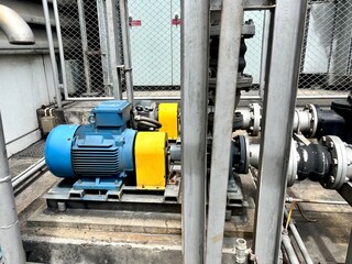 ndustrial electric motor and pump assembly connected to a series of pipes and flanges. The motor is...