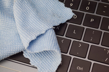 Close up microfiber cloth on laptop keyboard, concept of cleaning, technology care, and hygiene maintenance for electronic devices.
