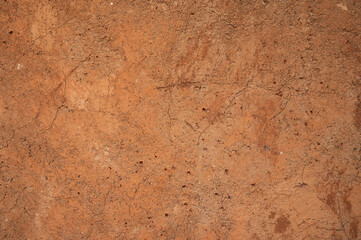 Full frame shot of an earthen wall texture of clay house structure. These walls are constructed by ramming a mixture of aggregates, including gravel, sand, silt and a small amount of clay.