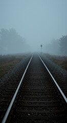 Obraz premium Foggy railway track extending into a misty distance