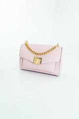 Light soft pink women's handbag on a white background. Stylish accessories and clothes