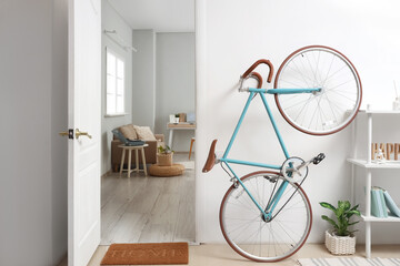 Modern bicycle near open door in hallway interior