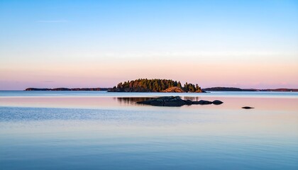 Serene lakeside scene with island and rocks at sunset with calm water reflections