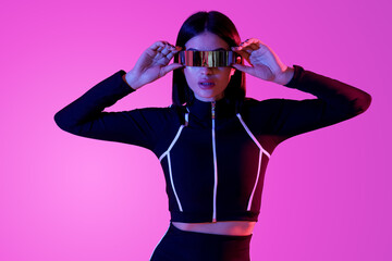 Young woman in VR glasses on pink background