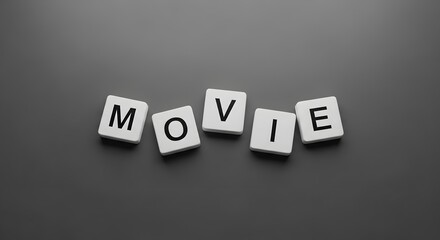 Obraz premium The word MOVIE spelled out with white letter tiles on a dark gray background.