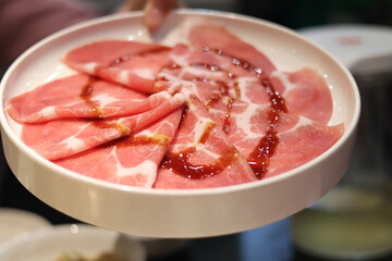 Pork, sliced ​​pork neck in a round plate for grilling and shabu