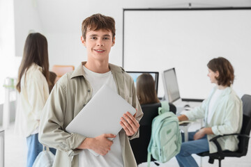 Obraz premium Male student with laptop at school computer lab