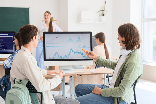 Male students studying at school computer lab, back view - Powered by Adobe