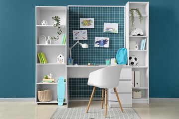 Interior of children's room with workplace, shelf units and pin board