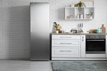 Interior of kitchen with modern fridge, counter and shelf