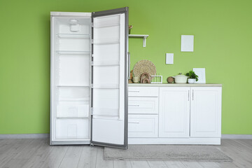 Interior of stylish kitchen with empty fridge and counters