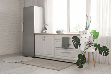 Interior of kitchen with modern fridge, counters and window
