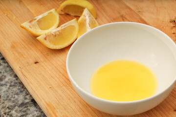Bowl of Melted Butter with Lemon Wedges