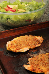 Cooked Chicken Cutlets Topped with Sunflower Seeds and Salad