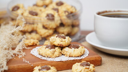 Homemade chocolate thumbprint cookies with peanut sprinkles and with hot black coffee, isolated on a clean white background. 
