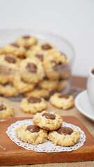 Homemade chocolate thumbprint cookies with peanut sprinkles and with hot black coffee, isolated on a clean white background. 