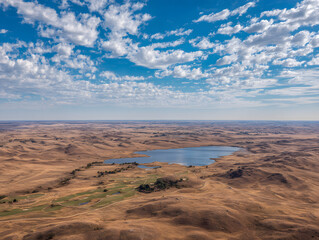 Aerial Vista over Nebraska Sandhills Calm Lake and Golf Course under a Bright Blue Sky with Fluffy White Clouds