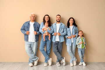 Portrait of big family in denim clothes near beige wall