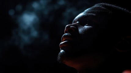 Pensive portrait of a man in dark light expressing deep emotions and atmospheric effects