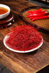 Fine Shredded Dried Red Chili Peppers on Wooden Table with Fresh Bell Peppers and Tea Cup