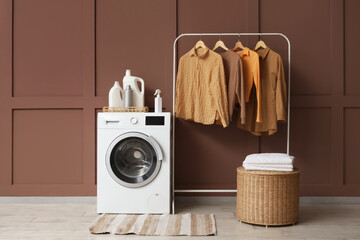 Interior of laundry room with washing machine, basket and clothes rack