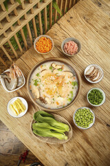Delicious Chinese Shrimp Mushroom Congee with Fresh Ingredients on Wooden Table