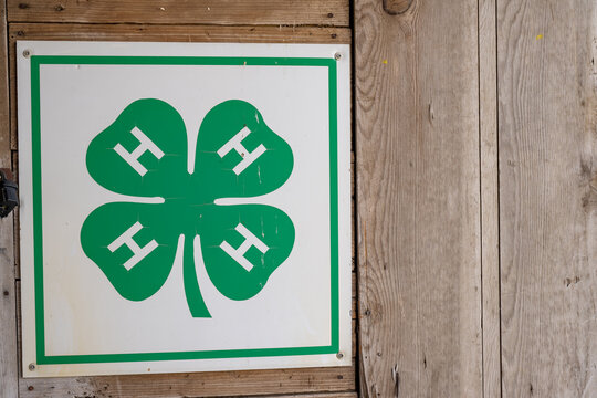 Hawkeye Point, Iowa, USA - 6.21.2025: Signage displaying green four-leaf clover emblem representing community youth organization in rural setting