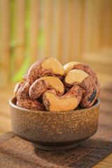 Salted roasted cashew nuts in ceramic bowl on wooden table healthy snack food ingredients