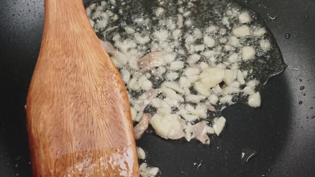 Frying sliced garlic in a pan, Close-up